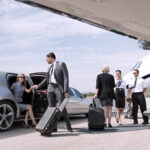 Business partners about to board private jet while airhostess an